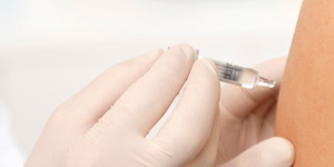 Apotheker impft Kundin am Arm mit der Zeckenimpfung in der Central-Apotheke Thalwil